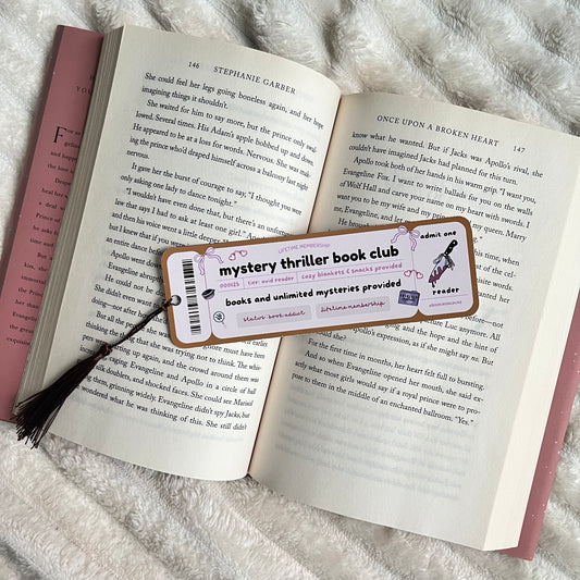 Open book with a mystery thriller book club bookmark on a textured surface